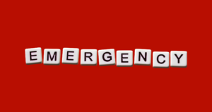 A red background with the letters spelling "emergency" laid out in a tile format.