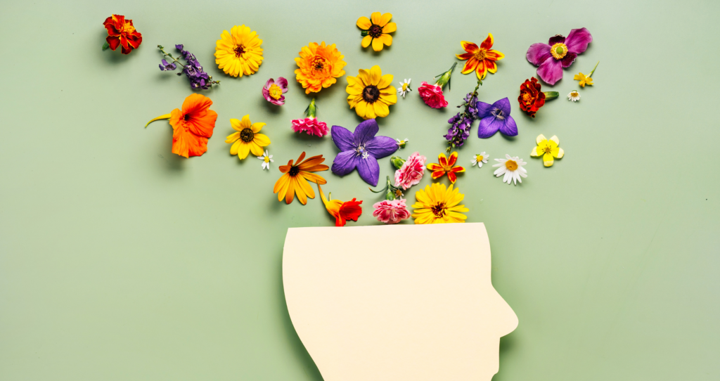 A paper cut out head with flowers coming out of it.